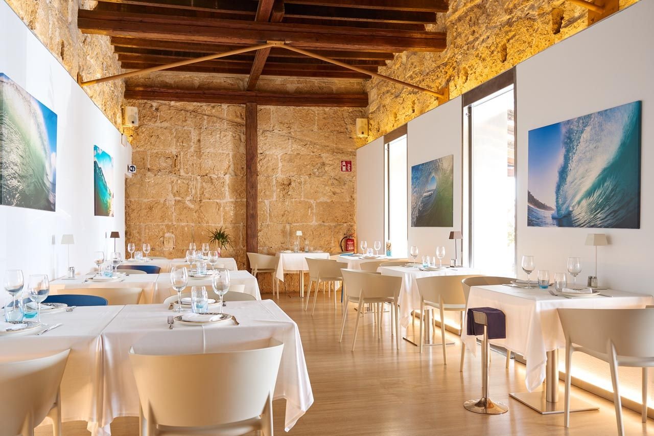 Sala de Ola del Mar: piedra de marés, vigas y mesas blancas
