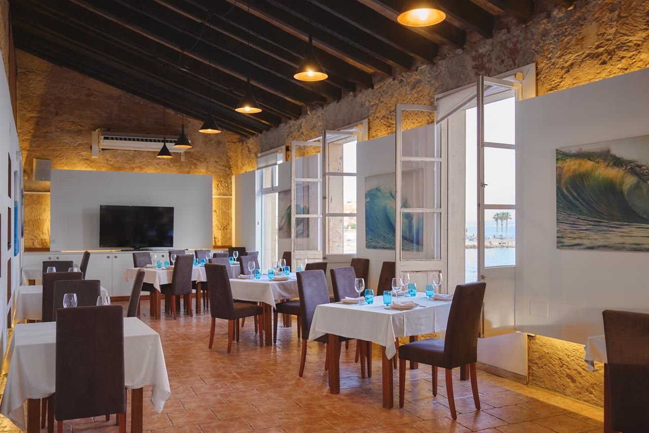 Salón privado con pantalla y ventanas al puerto