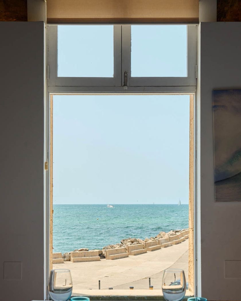 Ventana del comedor abierta a la playa y el mar